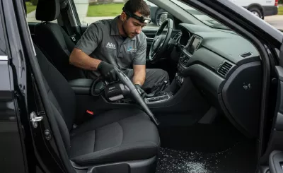 Technician cleaning door glass after replacement